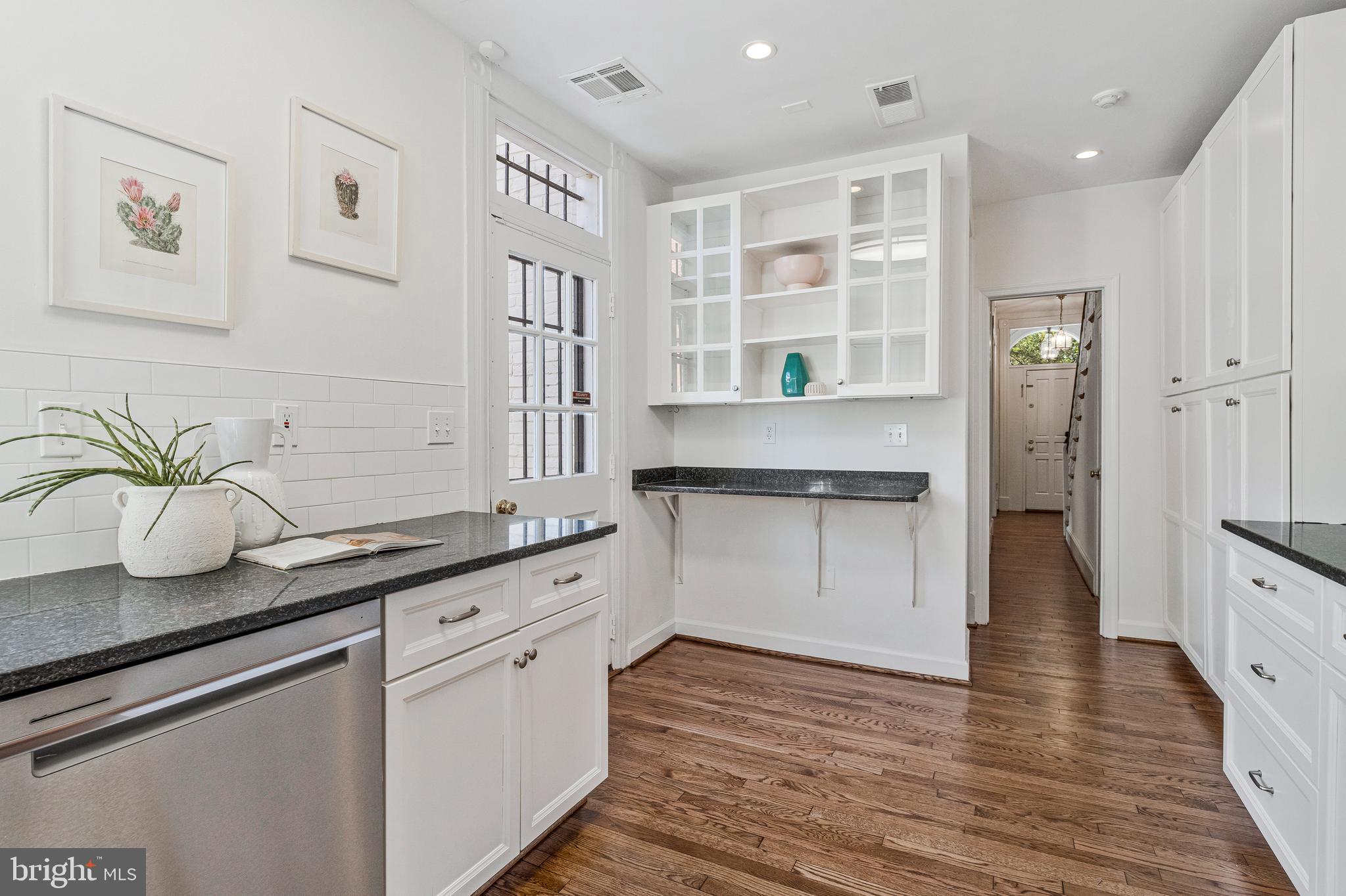 334 E Street Northeast Washington, DC 20002 - Photo 13 of 32 a kitchen with stainless steel appliances white cabinets and wooden floor