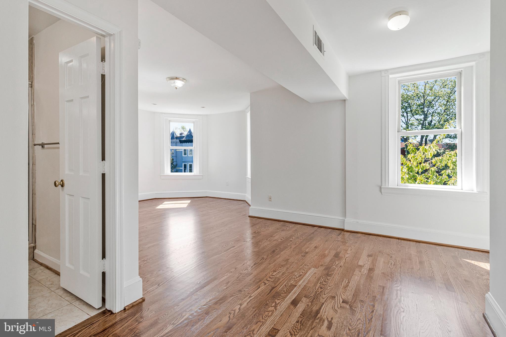 334 E Street Northeast Washington, DC 20002 - Photo 24 of 32 an empty room with wooden floor and windows
