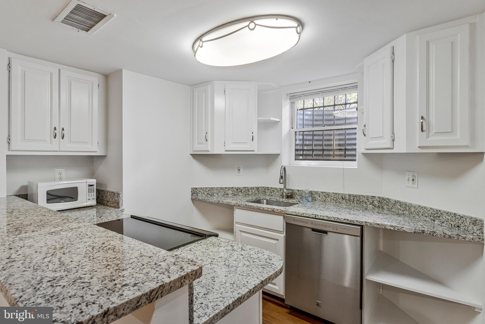 334 E Street Northeast Washington, DC 20002 - Photo 30 of 32 a kitchen with granite countertop a sink a stove and cabinets