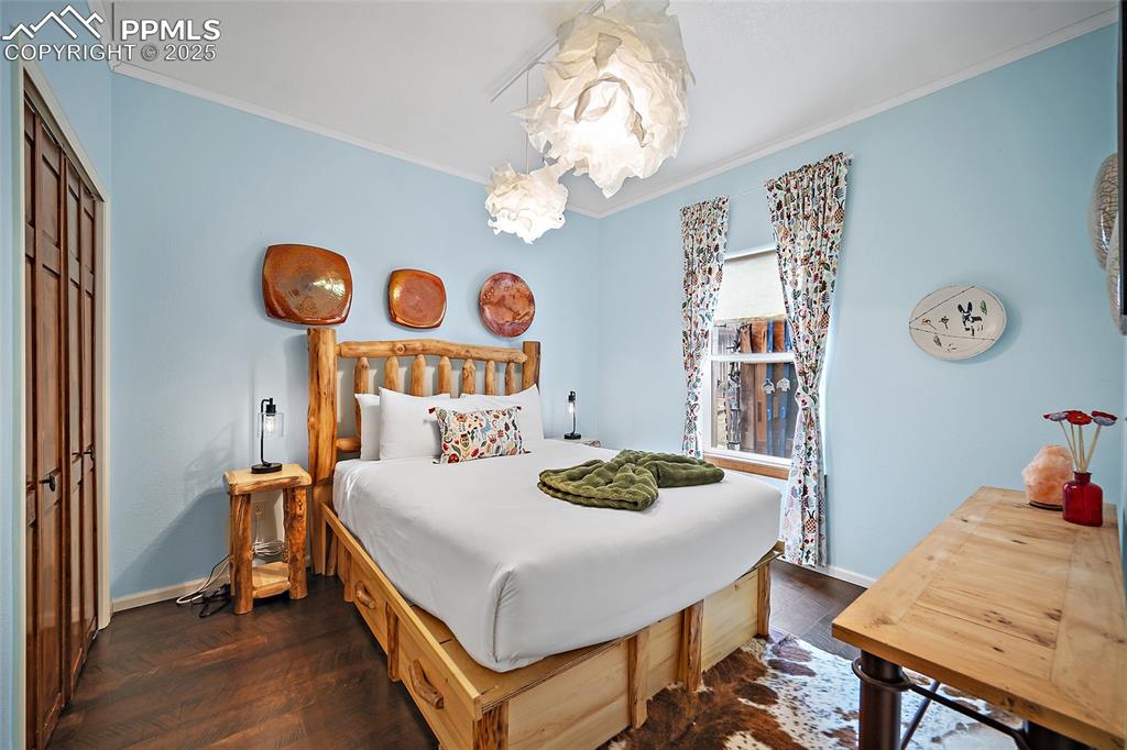 9845 Mesa Road Cascade, CO 80809 - Photo 16 of 50 a bedroom with a table and a chandelier