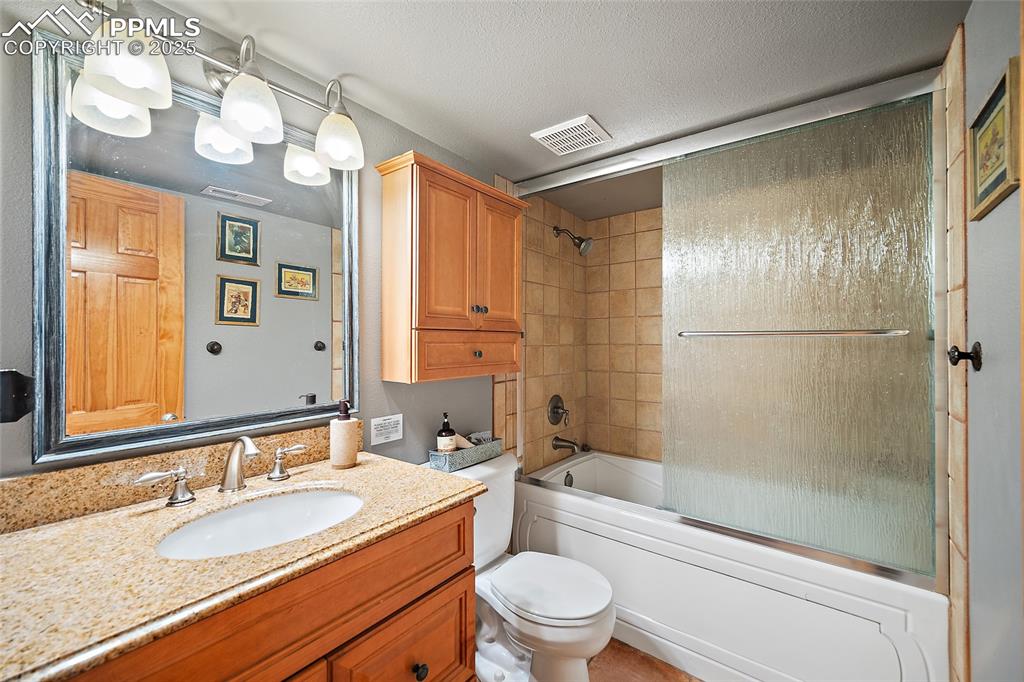 9845 Mesa Road Cascade, CO 80809 - Photo 27 of 50 a bathroom with a granite countertop sink toilet and shower