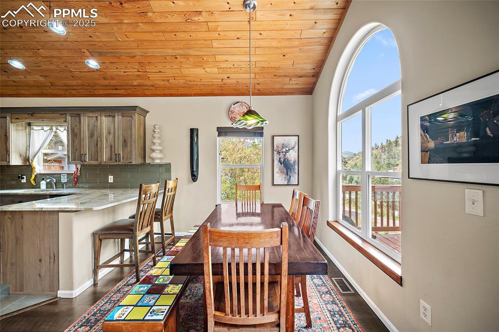 9845 Mesa Road Cascade, CO 80809 - Photo 7 of 50 a dining room with a furniture and a floor to ceiling window