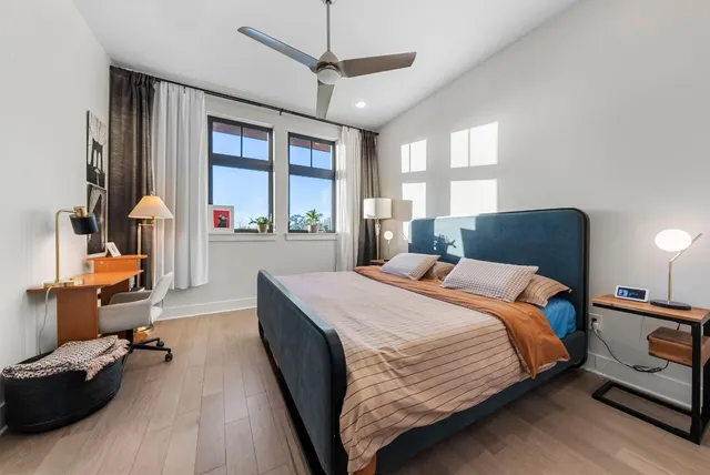 a bedroom with a bed couch and a large window