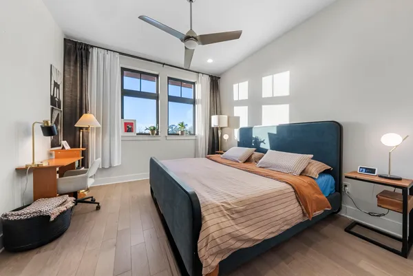 a bedroom with a bed couch and a large window