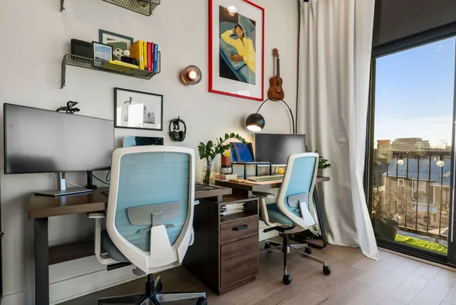 a view of a workspace with furniture and a window