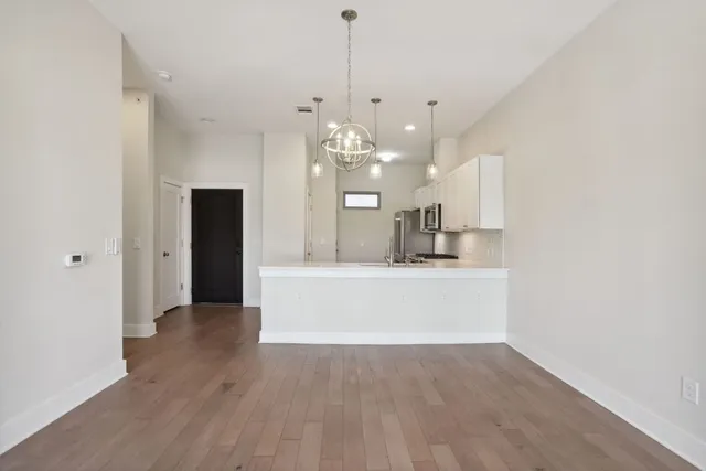 a view of a kitchen with a sink dishwasher a refrigerator and wooden floor