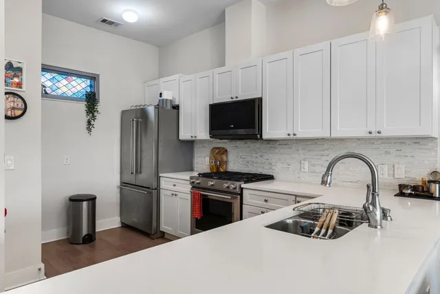 a kitchen with stainless steel appliances a refrigerator sink and microwave