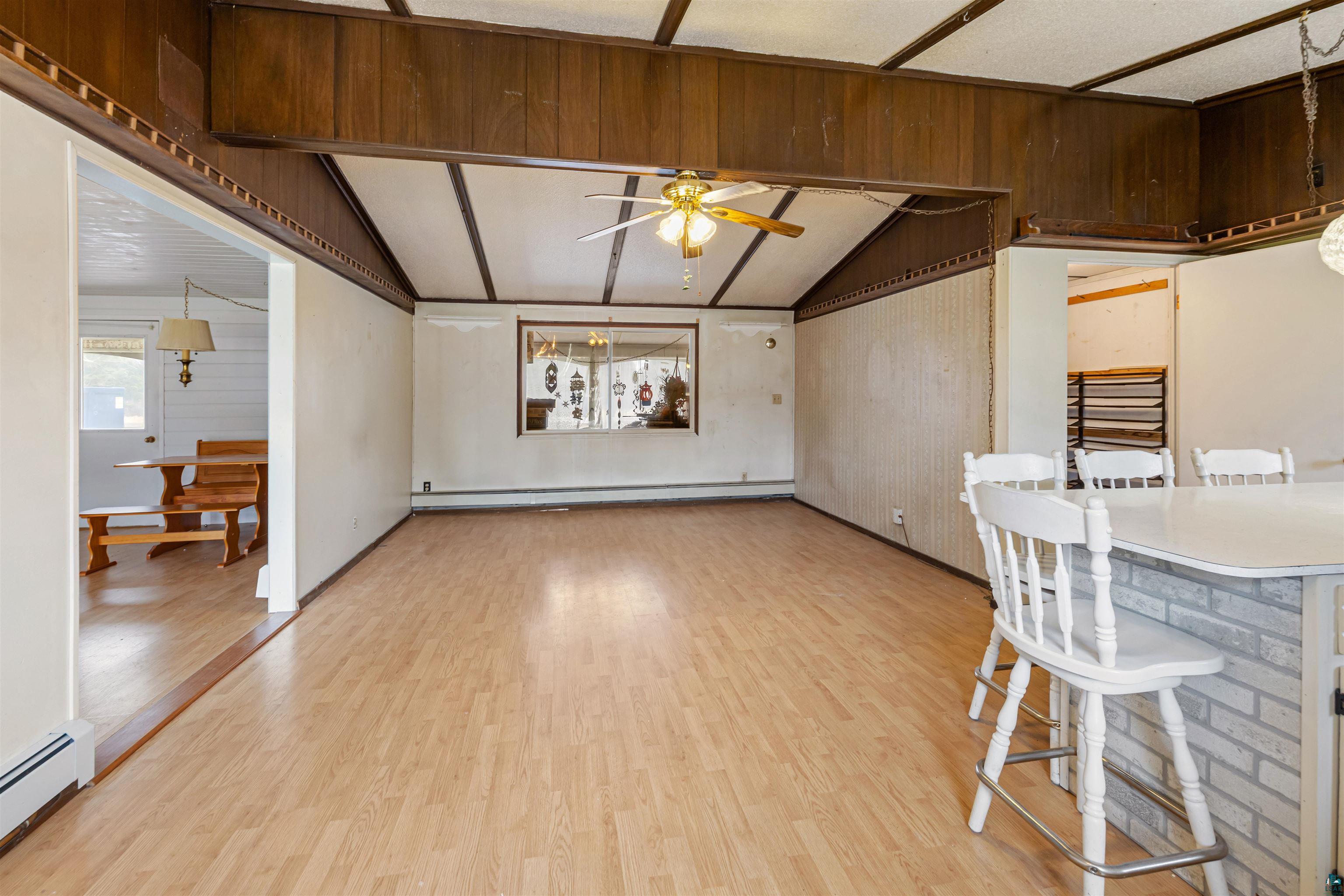 11574 Town Line Road Hibbing, MN 55746 - Photo 6 of 41 Expansive room featuring wood-finish flooring, vaulted ceiling with exposed wood beams, and a ceiling fan