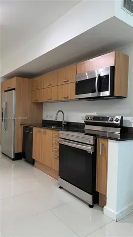 a kitchen with stainless steel appliances a stove a microwave and a sink