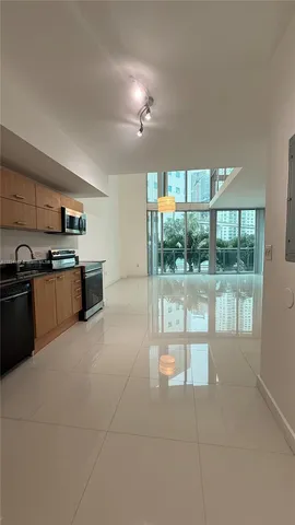 a large kitchen with granite countertop a stove a sink dishwasher and a microwave oven with cabinets