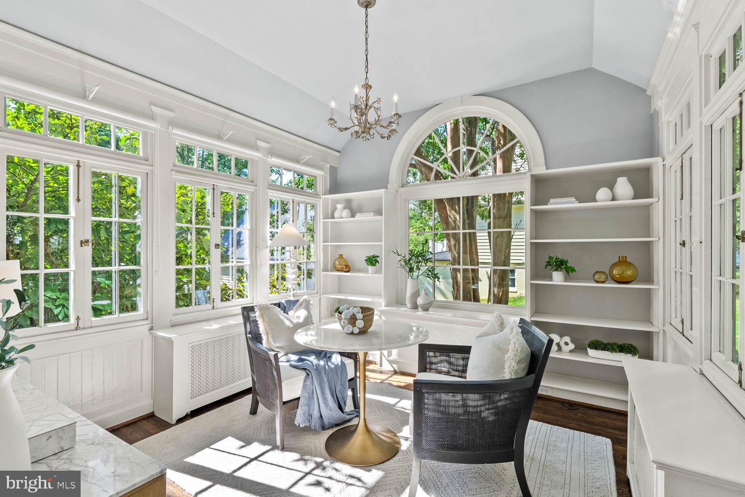 7406 Brookville Road Chevy Chase, MD 20815 - Photo 14 of 72 a view of a dining room with furniture large windows a chandelier and wooden floor