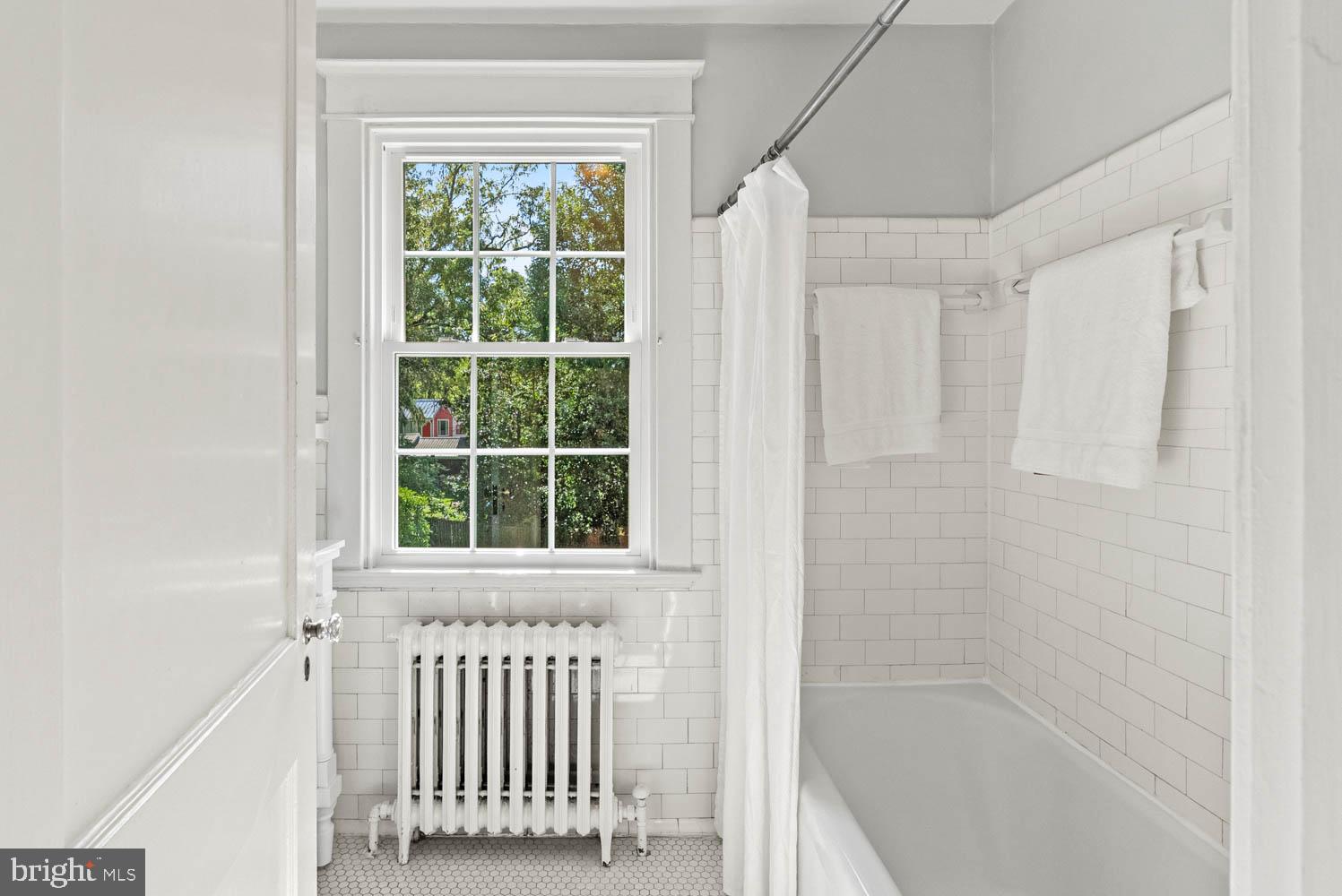 7406 Brookville Road Chevy Chase, MD 20815 - Photo 31 of 72 a bathroom with a window and a bathtub