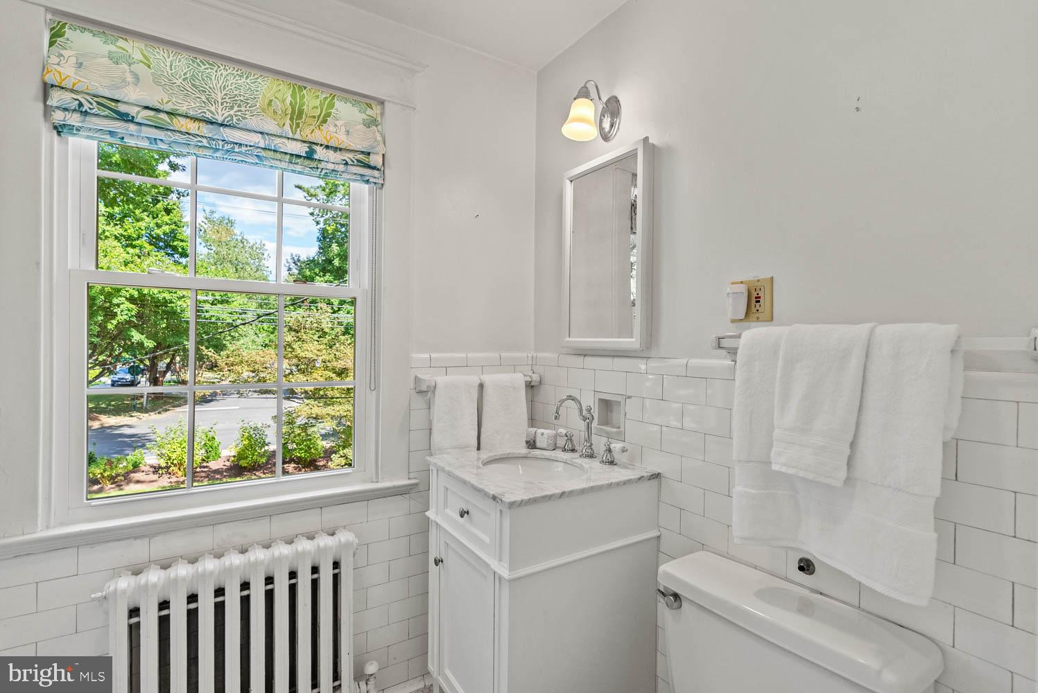7406 Brookville Road Chevy Chase, MD 20815 - Photo 37 of 72 a bathroom with a sink a toilet and a mirror