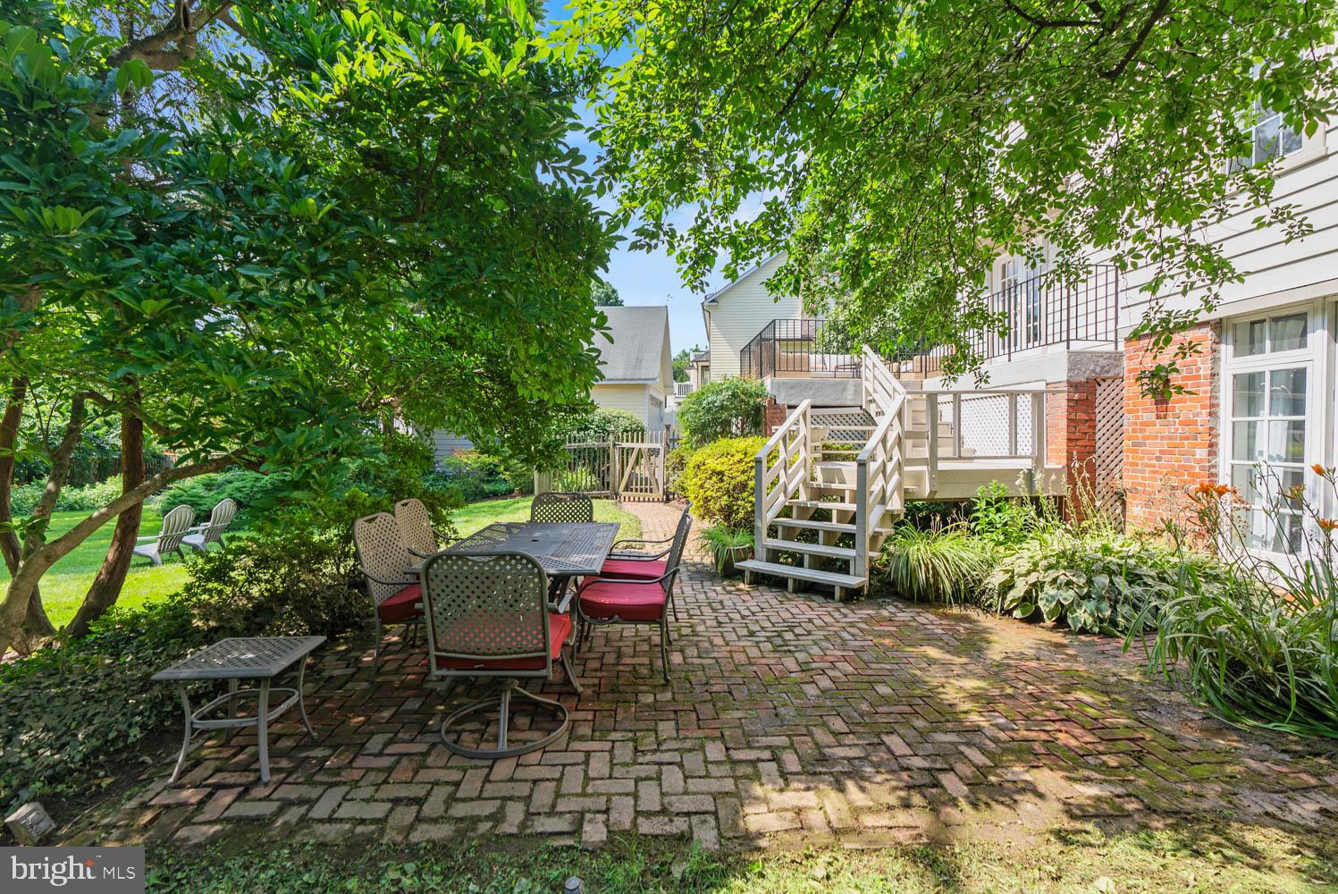 7406 Brookville Road Chevy Chase, MD 20815 - Photo 55 of 72 a view of a patio with table and chairs potted plants and large tree