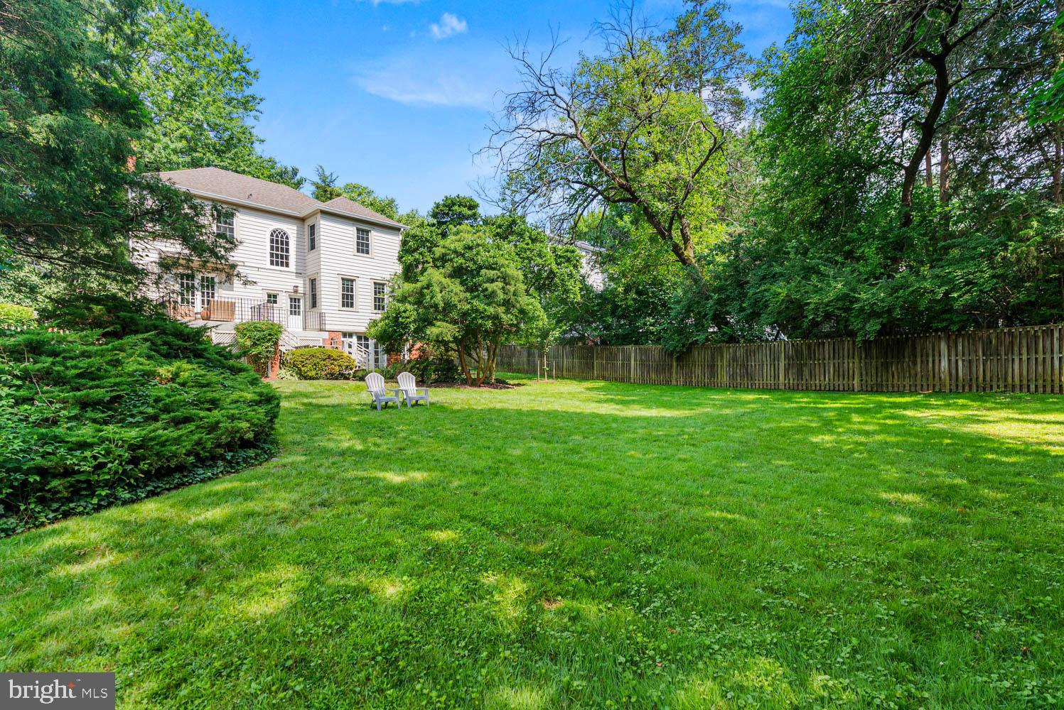 7406 Brookville Road Chevy Chase, MD 20815 - Photo 57 of 72 a view of a garden with a bench and trees in the back yard