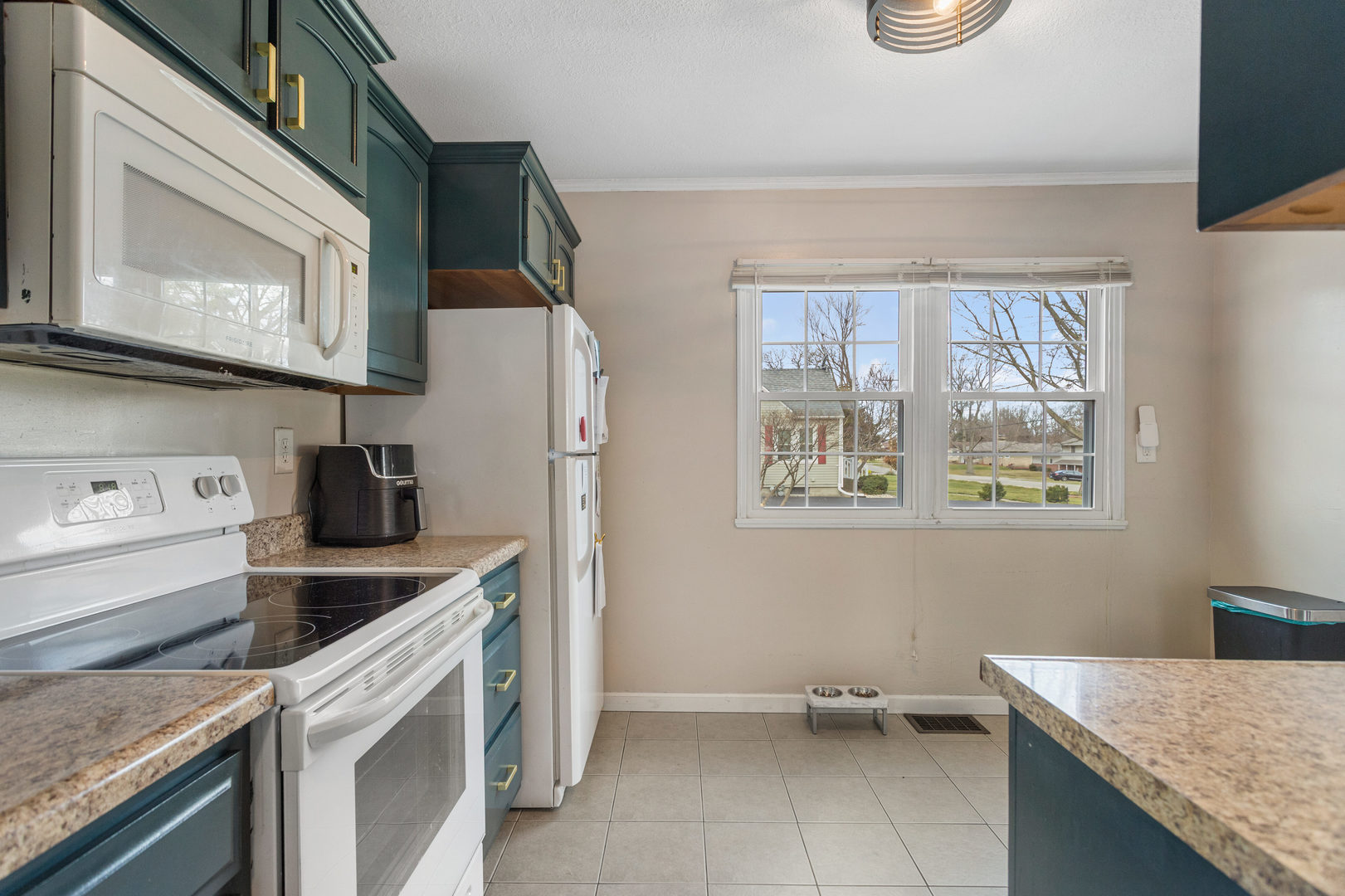 1351 West Pershing Road Decatur, IL 62526 - Photo 11 of 24 a kitchen with a stove a sink and a microwave