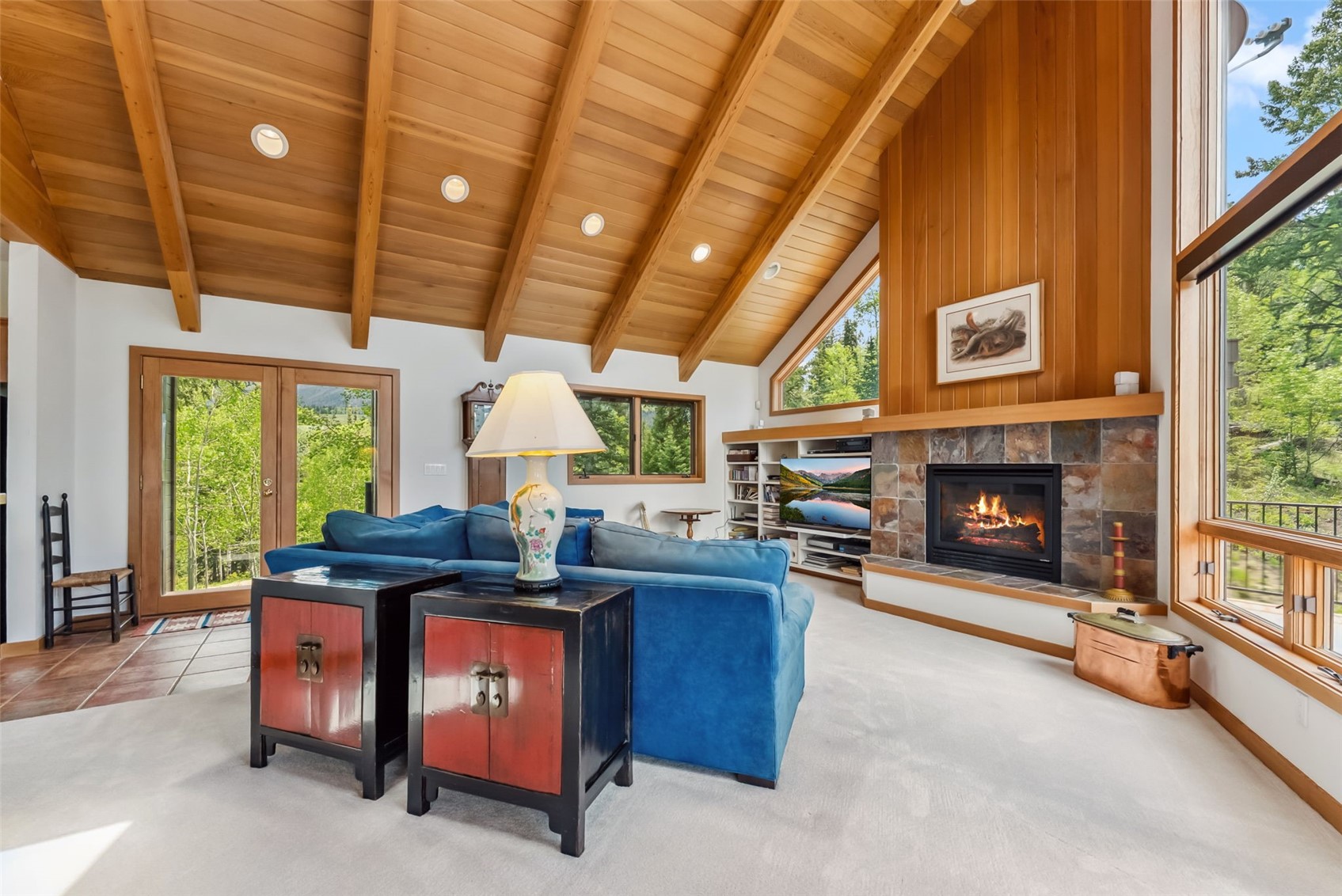 212 Spruce Ridge Road Silverthorne, CO 80498 - Photo 7 of 50 Carpeted living area with wood ceiling with exposed beams, a stone fireplace, and high vaulted ceiling