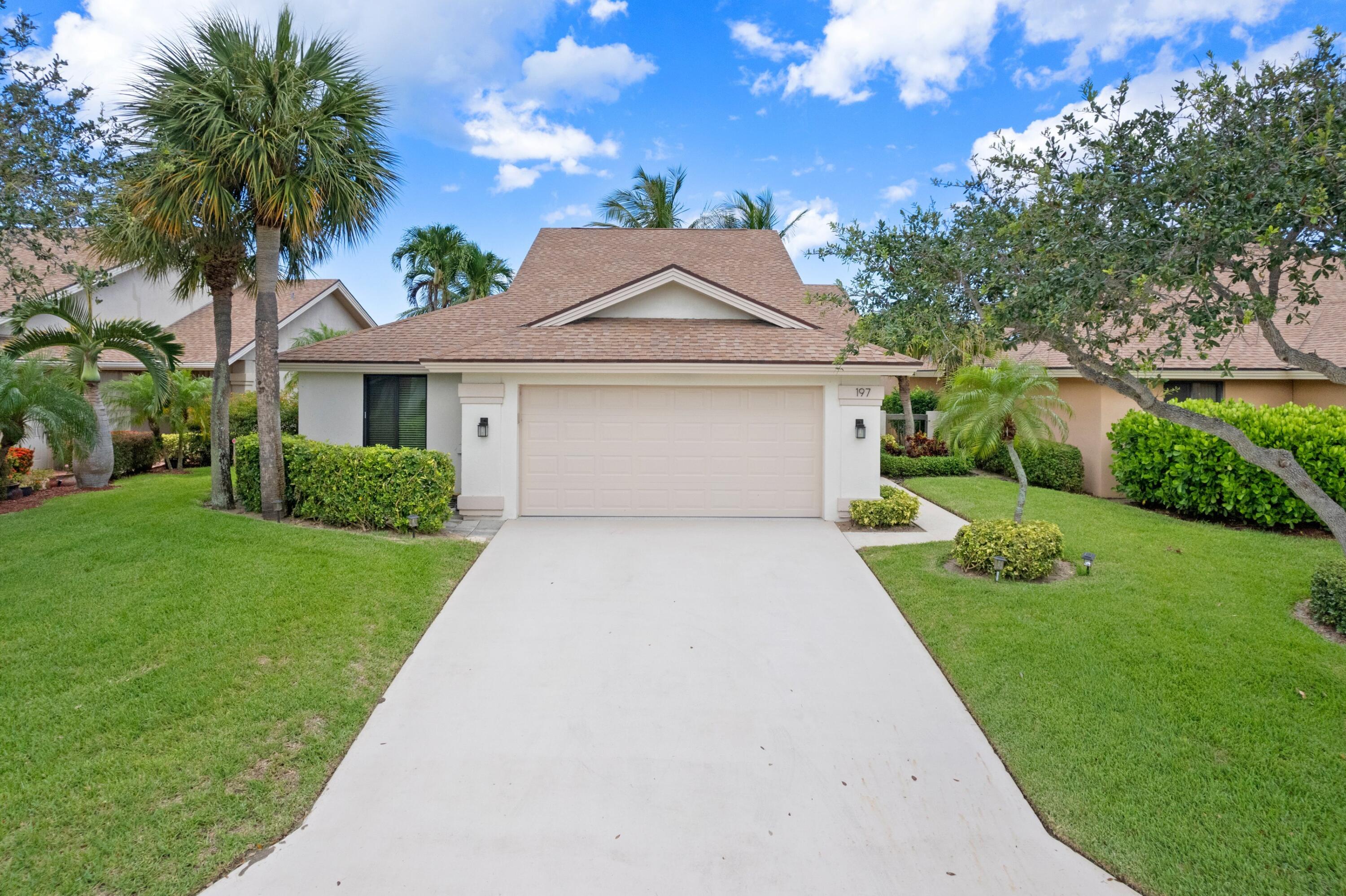 197 Ridge Road Jupiter, FL 33477 - Photo 20 of 44 a front view of a house with a yard and potted plants
