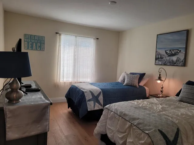 a bedroom with two bed and a window