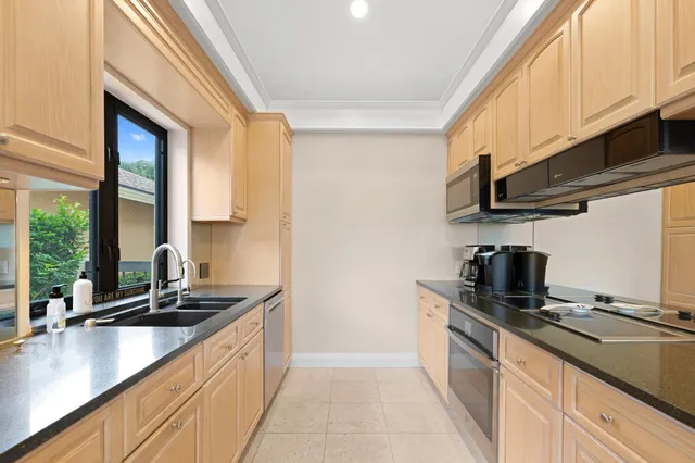 a kitchen with stainless steel appliances a sink a stove and a window