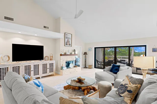 a living room with furniture a flat screen tv and a large window
