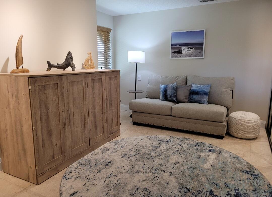 197 Ridge Road Jupiter, FL 33477 - Photo 4 of 44 a living room with furniture a lamp and a closet