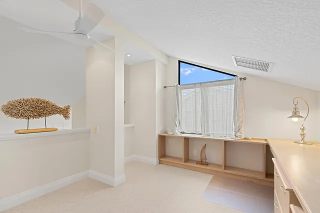 a view of an empty room with cabinet and a window
