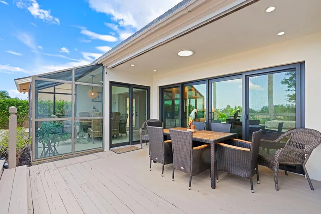 a dining room with furniture water view and a floor to ceiling window