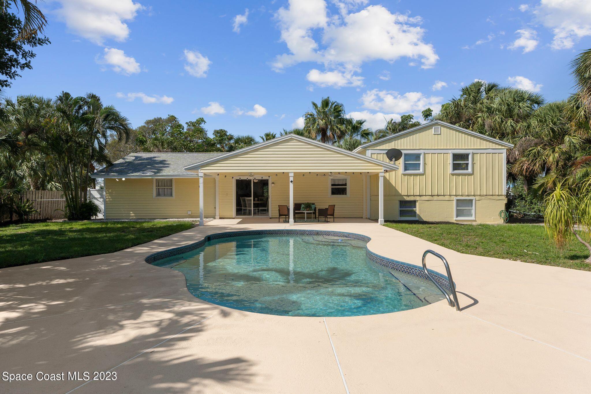 2007 Oak Street Melbourne Beach, FL 32951 - Photo 18 of 26 a view of a white house with a swimming pool and a yard