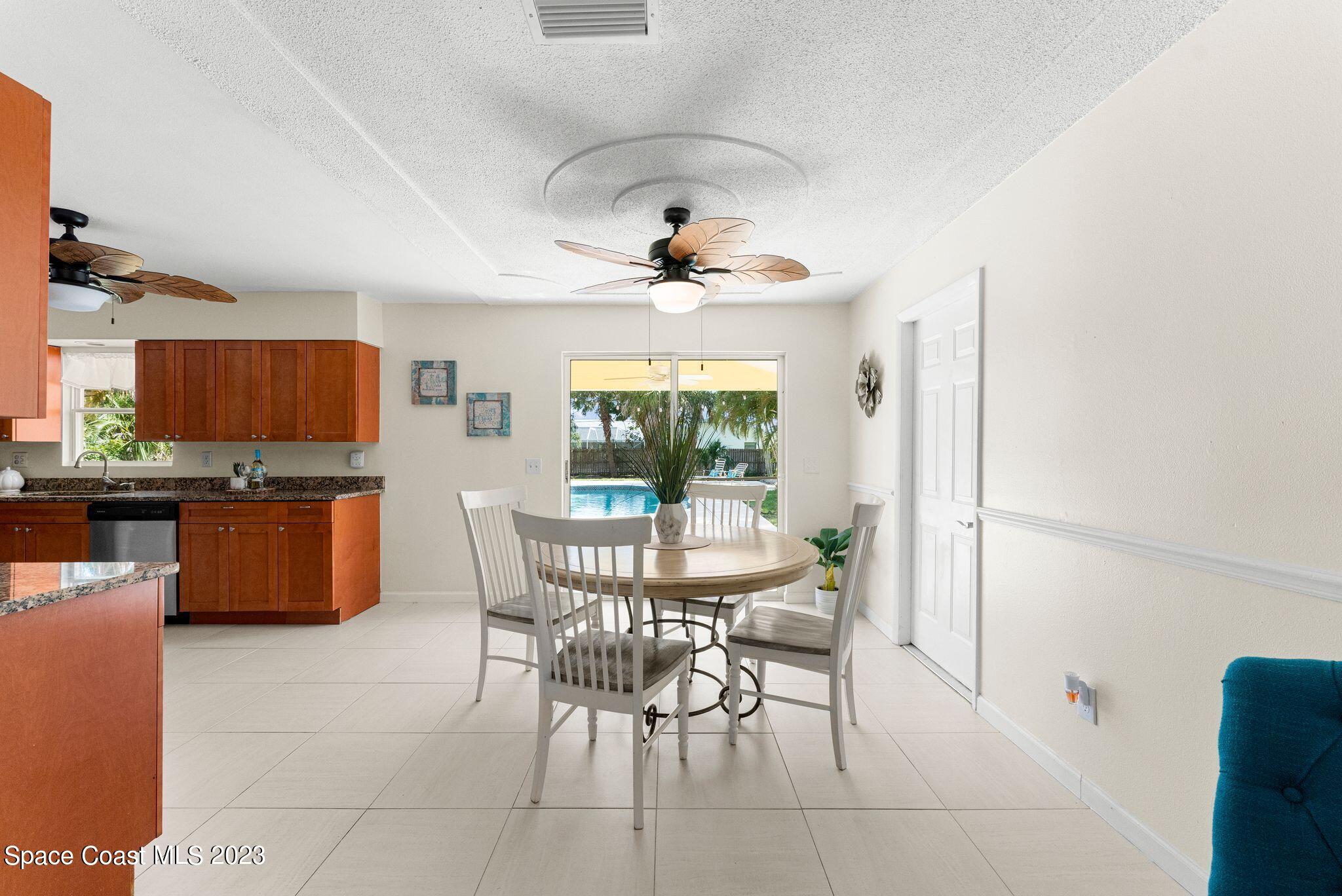 2007 Oak Street Melbourne Beach, FL 32951 - Photo 6 of 26 a dining room with furniture a large window and wooden floor
