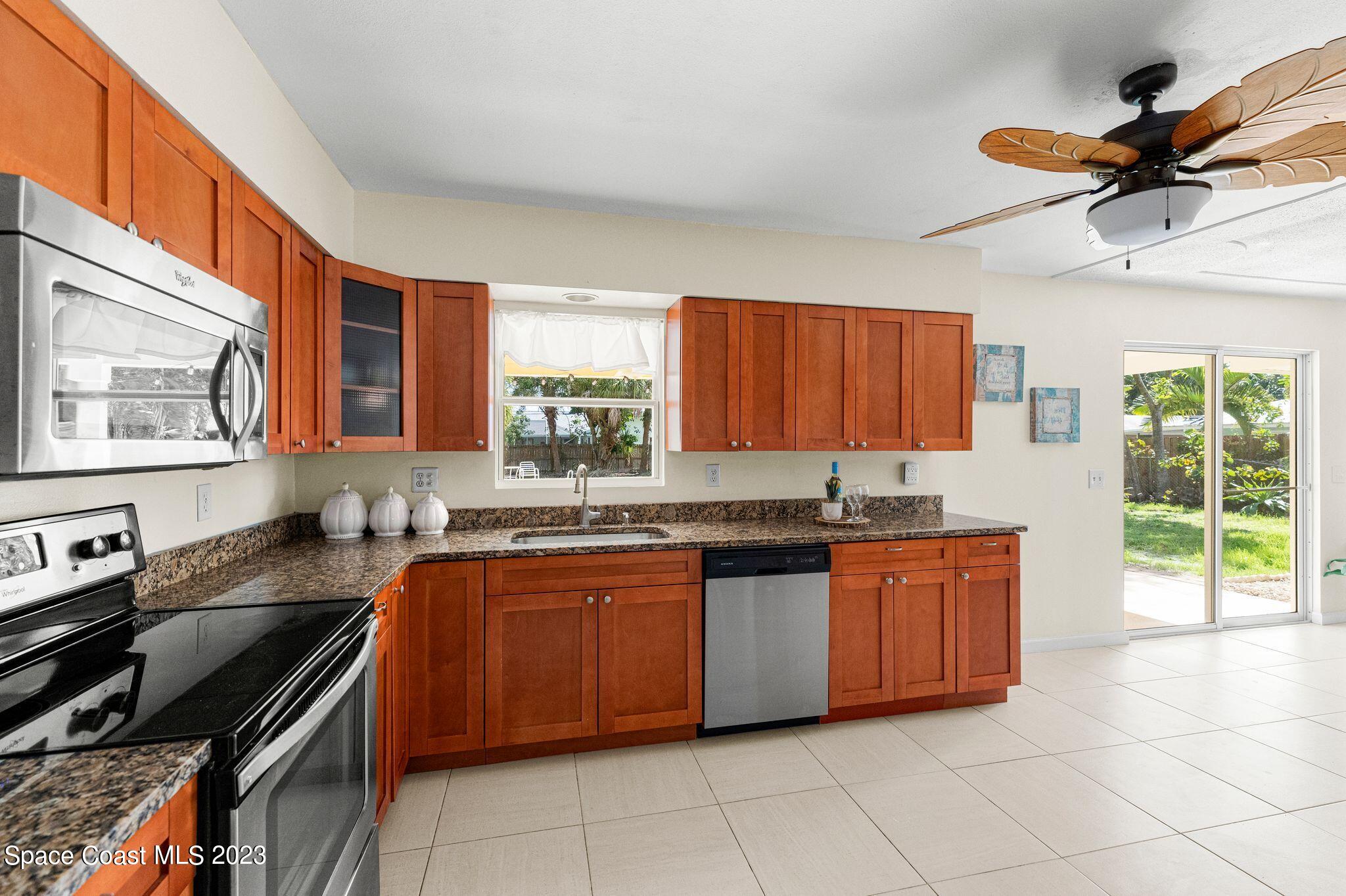 2007 Oak Street Melbourne Beach, FL 32951 - Photo 8 of 26 a kitchen with stainless steel appliances granite countertop a sink dishwasher stove and cabinets