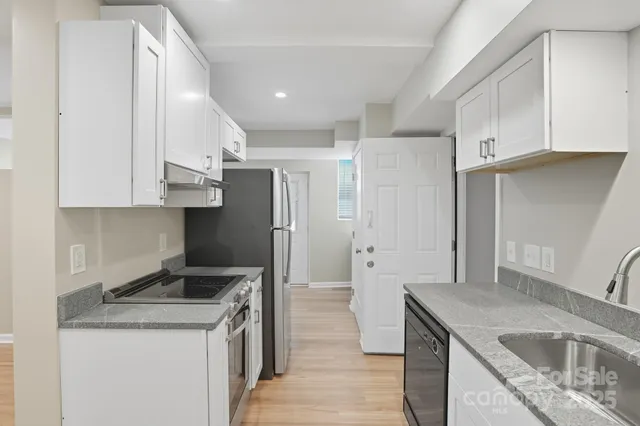 a kitchen with stainless steel appliances granite countertop a sink stove and refrigerator