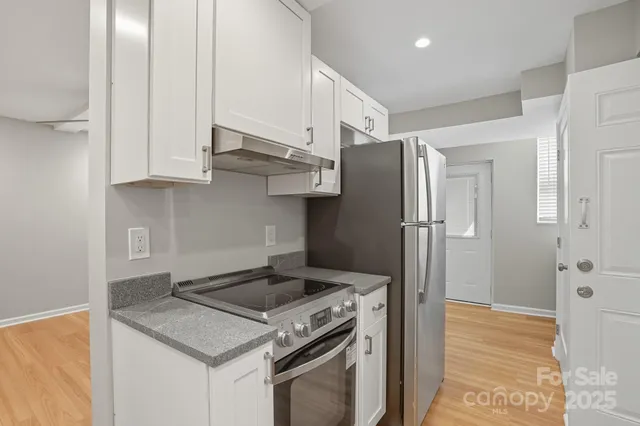 a kitchen with stainless steel appliances granite countertop a refrigerator and a stove