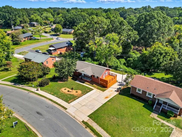 an aerial view of a tennis ground and trees in the background