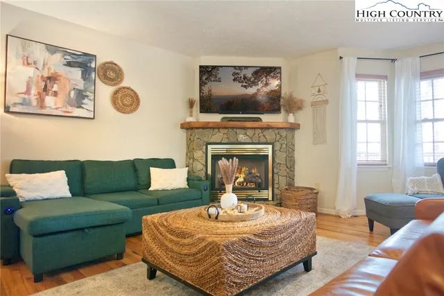 a living room with furniture a flat screen tv and a fireplace