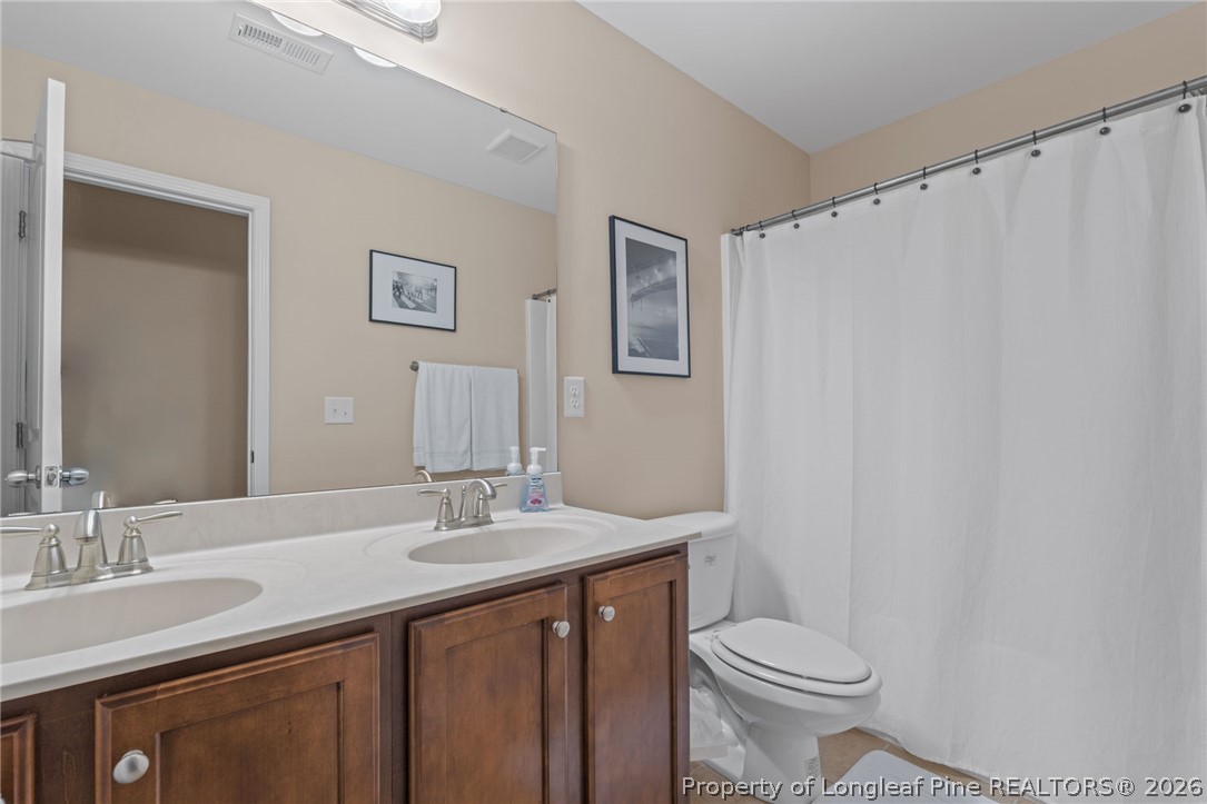 126 Pine Hawk Drive Spring Lake, NC 28390 - Photo 22 of 48 a bathroom with a sink a toilet and a mirror