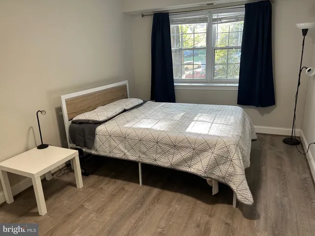 a bedroom with a bed window and chair