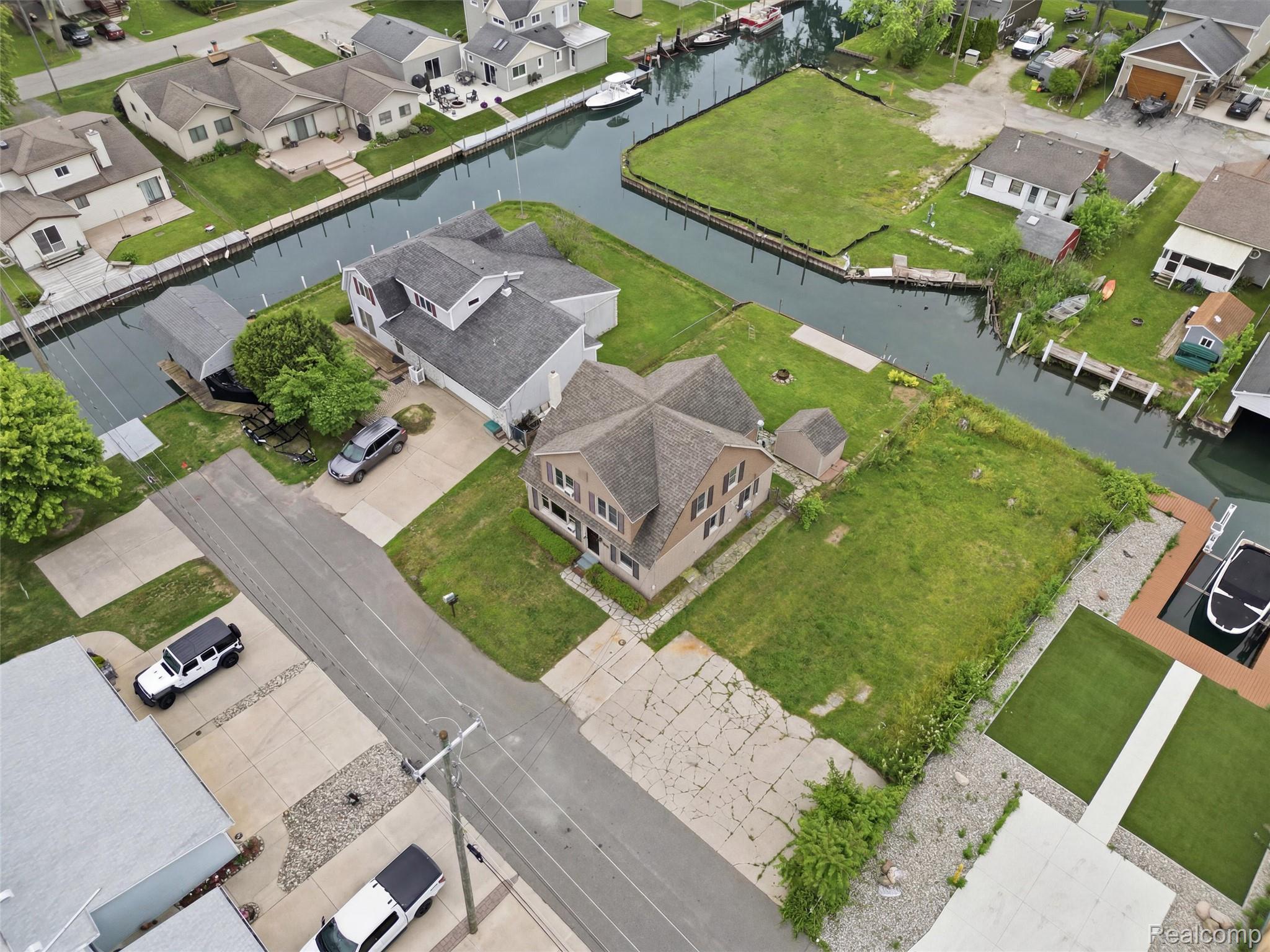117 Kenyon Road Algonac, MI 48001 - Photo 7 of 47 Aerial perspective showcasing a canal-front property with a multi-story residence