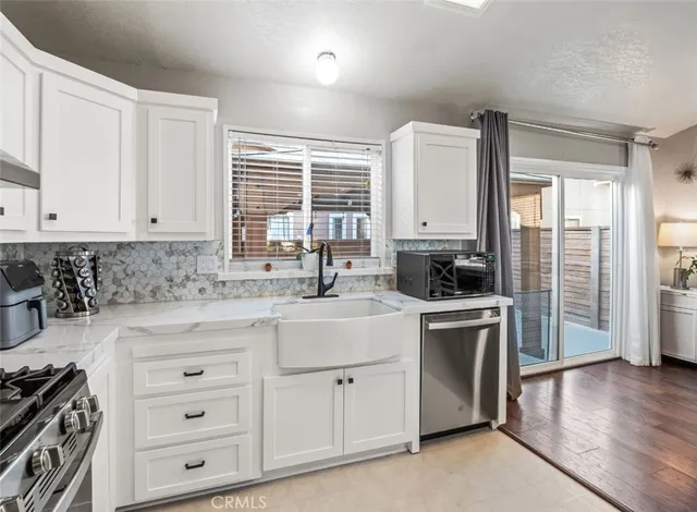 a kitchen with stainless steel appliances granite countertop a sink a stove and cabinets