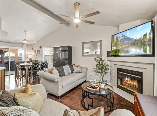 a living room with furniture a flat screen tv and a fireplace
