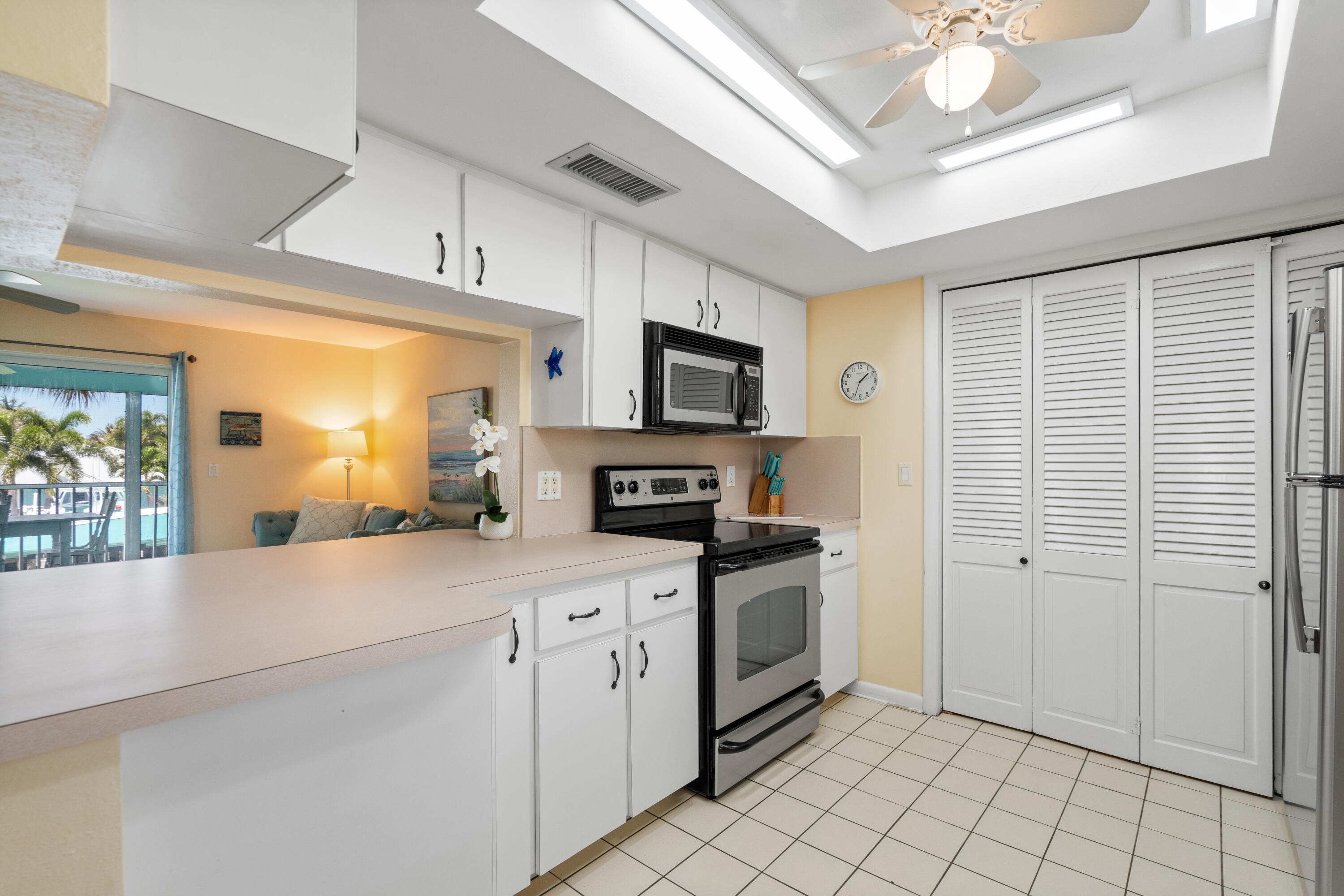 249 Center Street, Unit 2C Jupiter, FL 33458 - Photo 16 of 29 a kitchen with granite countertop a sink stainless steel appliances and cabinets