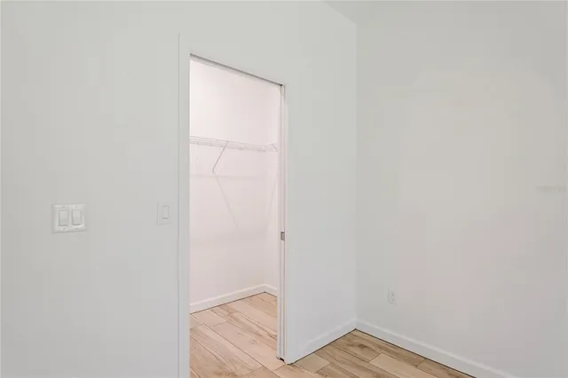 an empty room with wooden floor and window