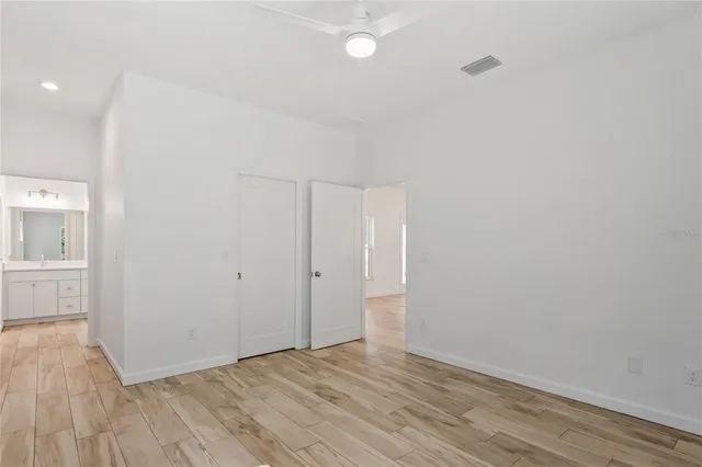 a view of kitchen with microwave a refrigerator and a stove top oven with wooden floor