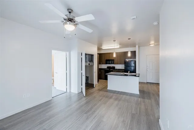 a view of kitchen with refrigerator microwave and stove with wooden floor