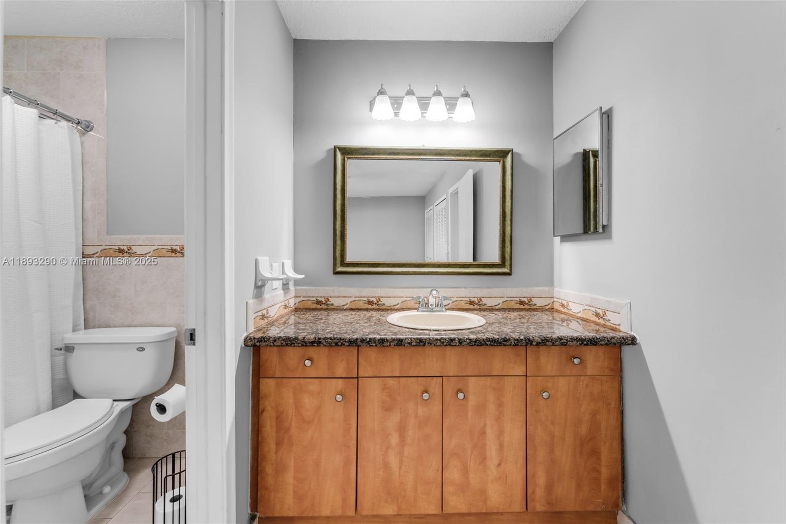 10121 Southwest 4th Street Miami, FL 33174 - Photo 19 of 31 a bathroom with a granite countertop toilet sink and mirror