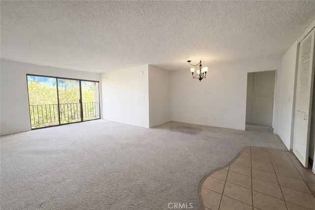 a view of a big room with windows and chandelier fan