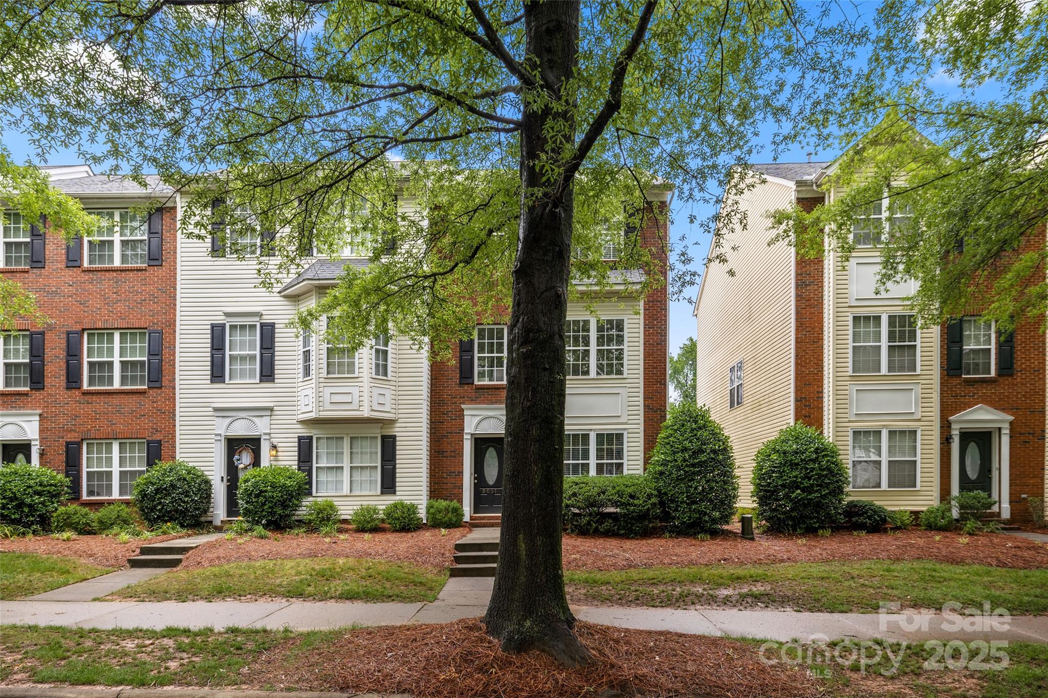 9651 Bailey Road Cornelius, NC 28031 - Photo 2 of 32 a view of a brick building next to a yard with large trees