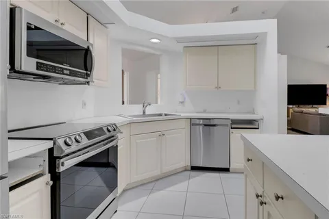 a kitchen with stainless steel appliances white cabinets and a stove top oven