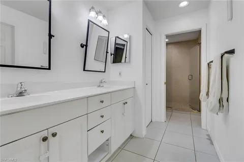 a bathroom with a double vanity sink mirror and shower