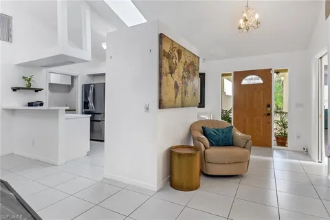 a living room with furniture and a refrigerator